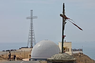 Traditional windmill by building against sky