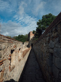 Stone wall of old building against sky