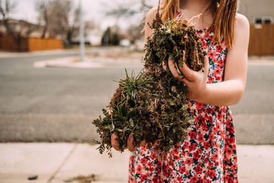 Cropped image of young girl hold large chunks of dirt