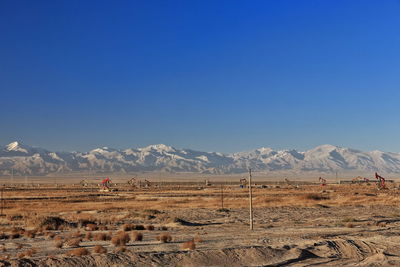 Scenic view of desert against clear blue sky