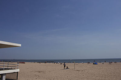 Group of people at beach against sky