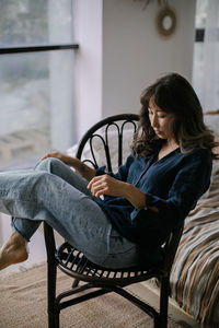 Young woman sitting on sofa at home