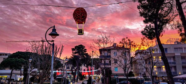 Low angle view of street lights against sky at sunset