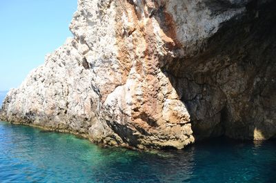 Rock formation in sea against sky