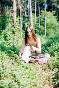 Portrait of smiling young woman sitting on land