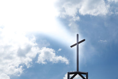 Low angle view of cross against sky