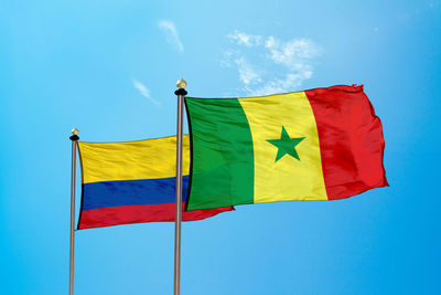 Low angle view of flag against blue sky