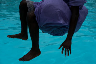 Low section of man swimming in pool