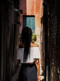 Rear view of woman standing in corridor