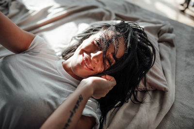 Portrait of woman lying on bed at home