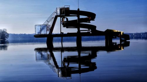 Silhouette boat on lake against sky