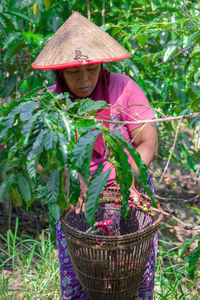 Portrait of woman holding basket of plants