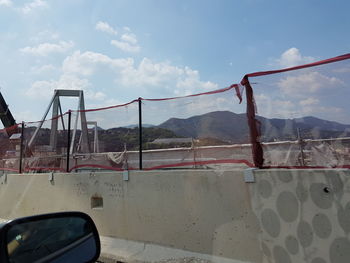 Built structure against sky seen through car windshield