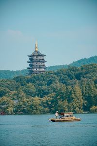 Boat in lake by building against sky