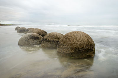 Rocks on beach against sky