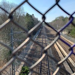 Railroad tracks seen through chainlink fence