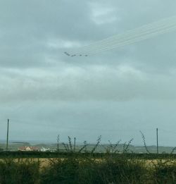 Low angle view of field against cloudy sky