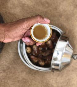 High angle view of hand holding coffee cup