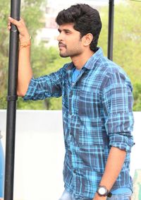 Young man looking away while standing outdoors