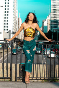 Portrait of smiling woman standing against buildings in city