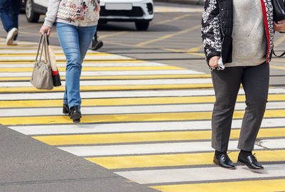 Low section of people walking on road