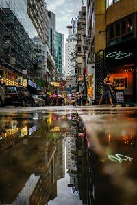 Reflection of illuminated buildings on street in city