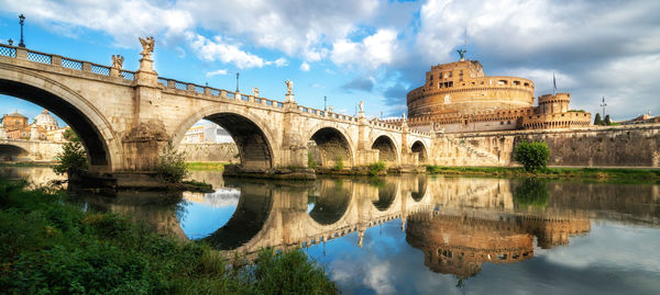 Arch bridge over river against sky