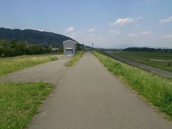 Empty road leading towards field