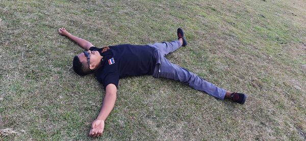 High angle view of young man lying on land