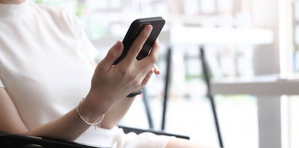 Midsection of woman using mobile phone