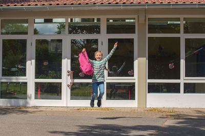 The schoolgirl is jumping for the joy of returning to school. the beginning of the school year.