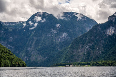 Scenic view of lake by mountains against sky