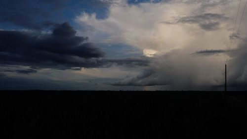 Scenic view of dramatic sky over silhouette landscape