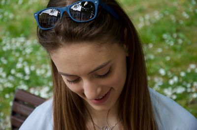 Close-up of young woman looking down sitting on bench