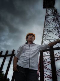 Low angle view of man looking away against sky