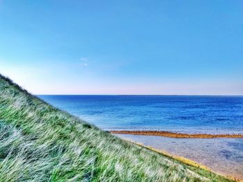 Scenic view of sea against clear blue sky