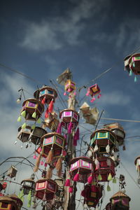 Low angle view of umbrellas hanging against sky in city