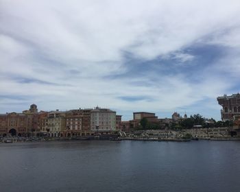 Buildings in city against cloudy sky