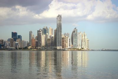 Buildings in city against cloudy sky