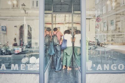 People in city seen through glass window