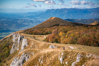 Woman mountain biking on footpath near ridge on mount nanos above vipava, slovenia.