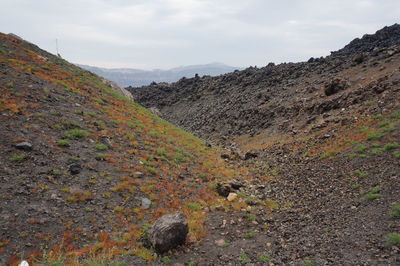 Scenic view of land and mountains against sky