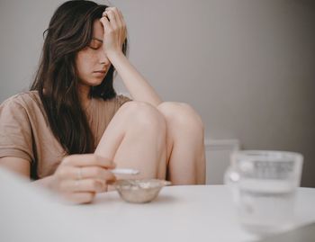 Sad woman with the cigarette on the kitchen