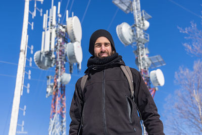 Portrait of young man standing against sky