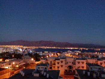 High angle view of illuminated cityscape against sky at night