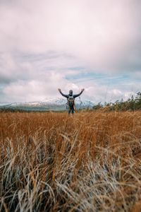 Man standing on field against sky