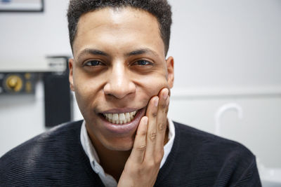 Portrait of young man with toothache sitting in hospital