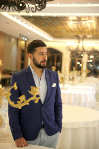 Man looking away while standing at restaurant