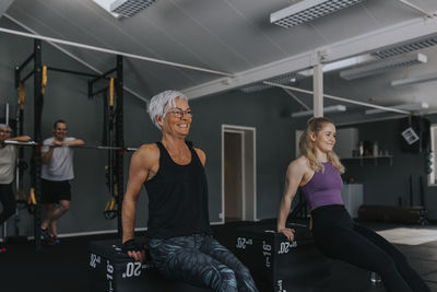 Smiling women training together in gym