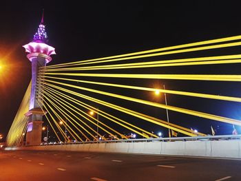 Illuminated bridge against sky at night